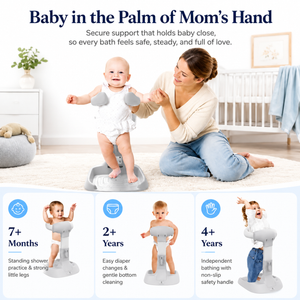 Baby standing supported in the shower stand while a parent rinses their hair with a handheld shower head